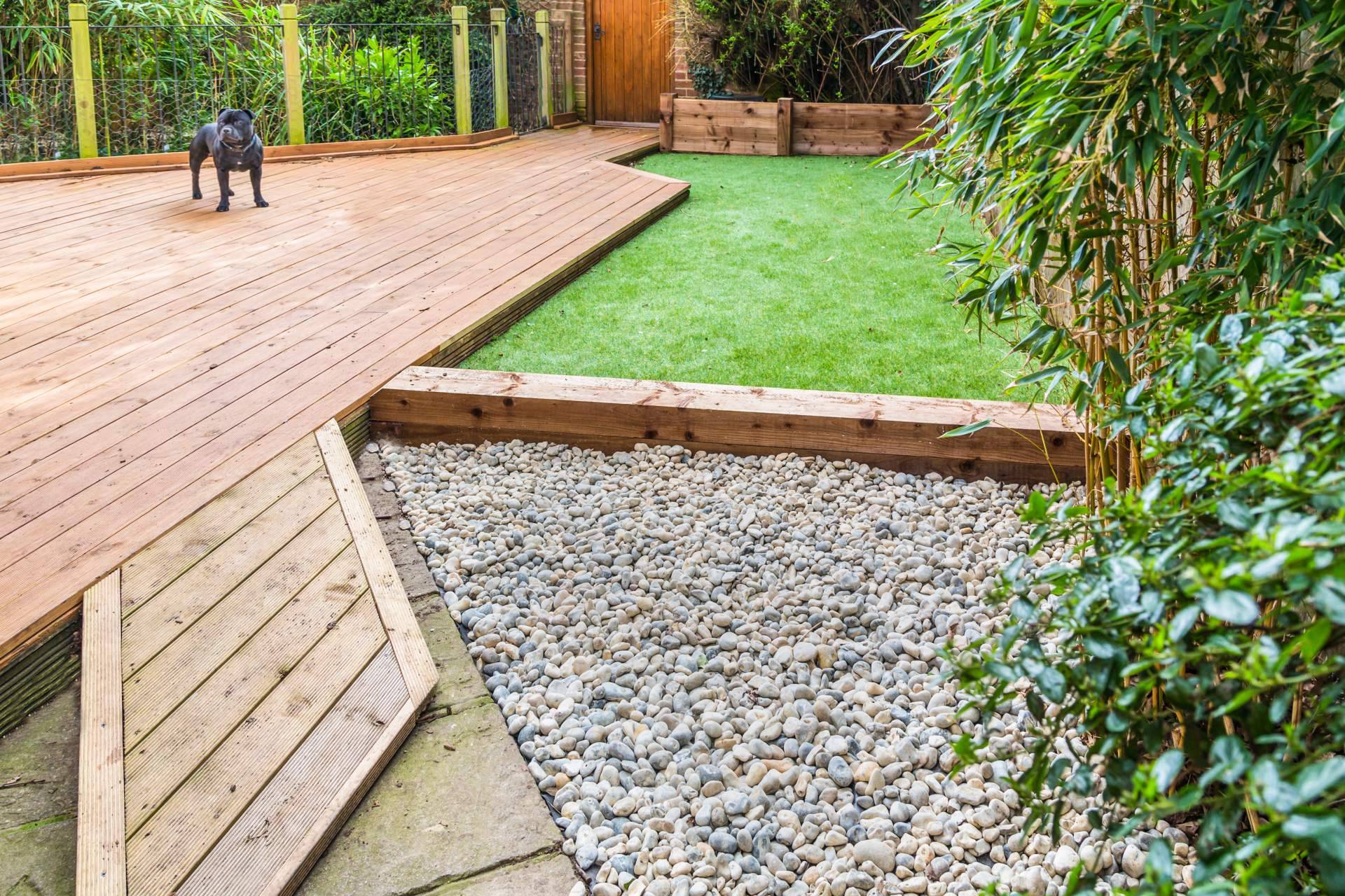 Decorar terrazas con jardines con piedras blancas y césped artificial
